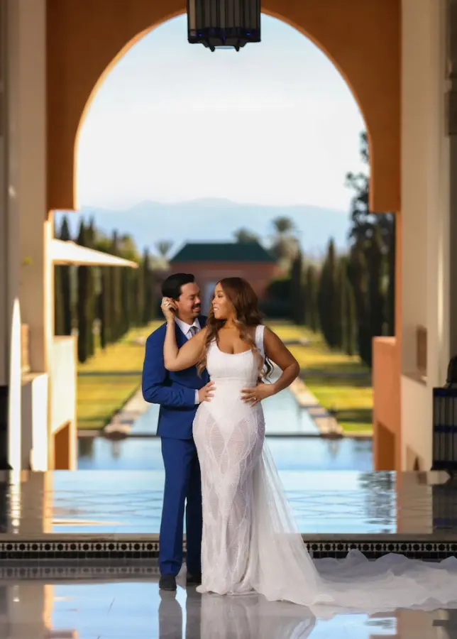 Couple embracing under an arch above a reflecting pool - couple photoshoot Marrakech