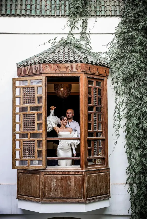 Couple framed in a carved wooden riad window - riad wedding photography Marrakech